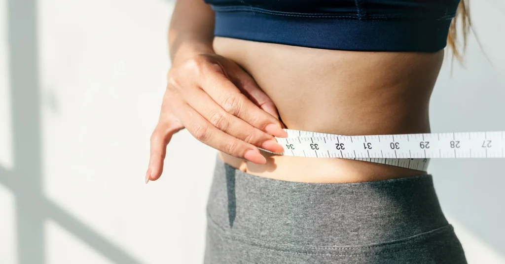 Kobieta mierzy obwód w pasie