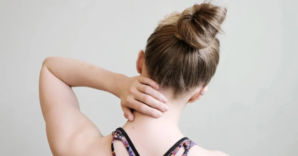 Kobieta trzyma się za szyję