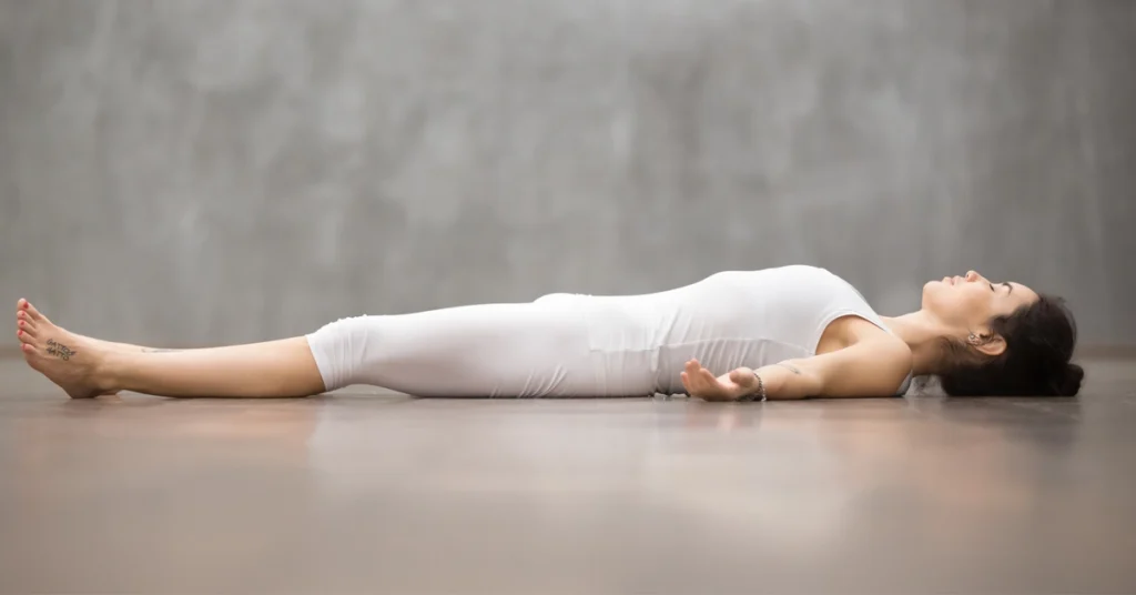 Kobieta leży w pozycji savasana