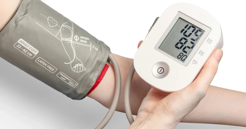 Osoba mierzy sobie ciśnienie krwi za pomocą elektronicznego ciśnieniomierza